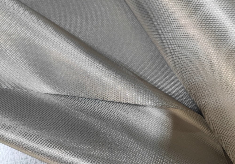 Military Grade Silver EMF Shielding Fabric Texture | Redemption Shield Close up of folded silver military grade EMF shielding fabric showing its woven conductive texture for RF shielding and Faraday protection by Redemption Shield.
