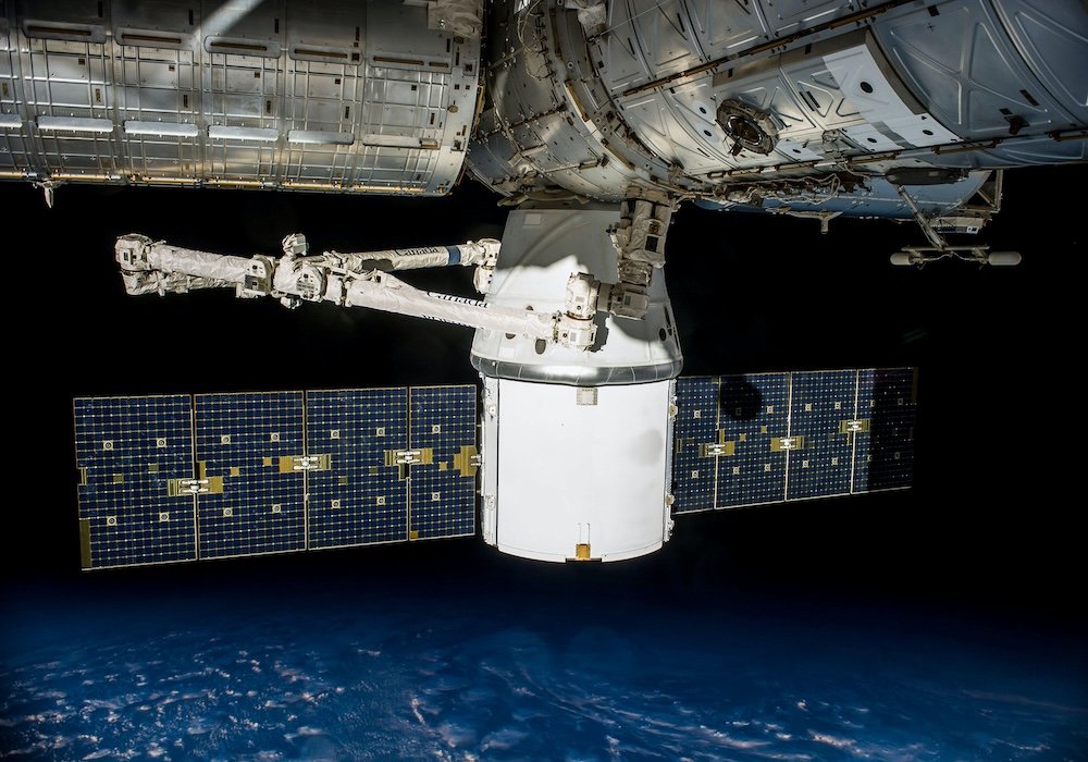 Assessing Benefits vs Health and Safety Risks of 5G Satellites 4 Satellite and solar panels in orbit above Earth, illustrating a discussion of 5G satellite technology and potential health and safety concerns.