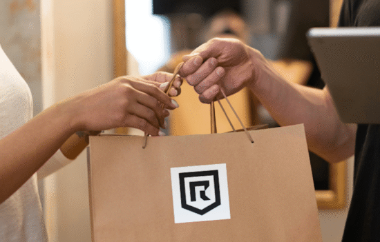 Real Customer Experiences: EMF Protection, Grounding, and Earthing Products That Make a Difference 8 Customer receiving a Redemption Shield order in a shopping bag featuring the Redemption Shield logo.