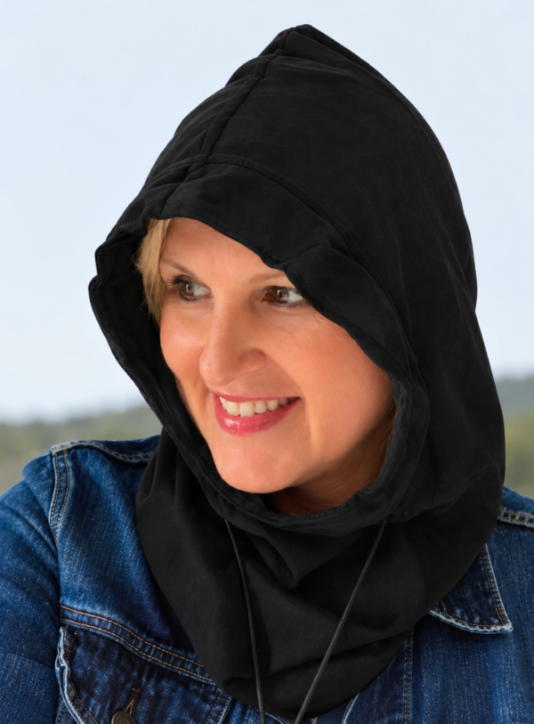 Woman wearing a black EMF protection shielding hood and blue denim jacket outdoors